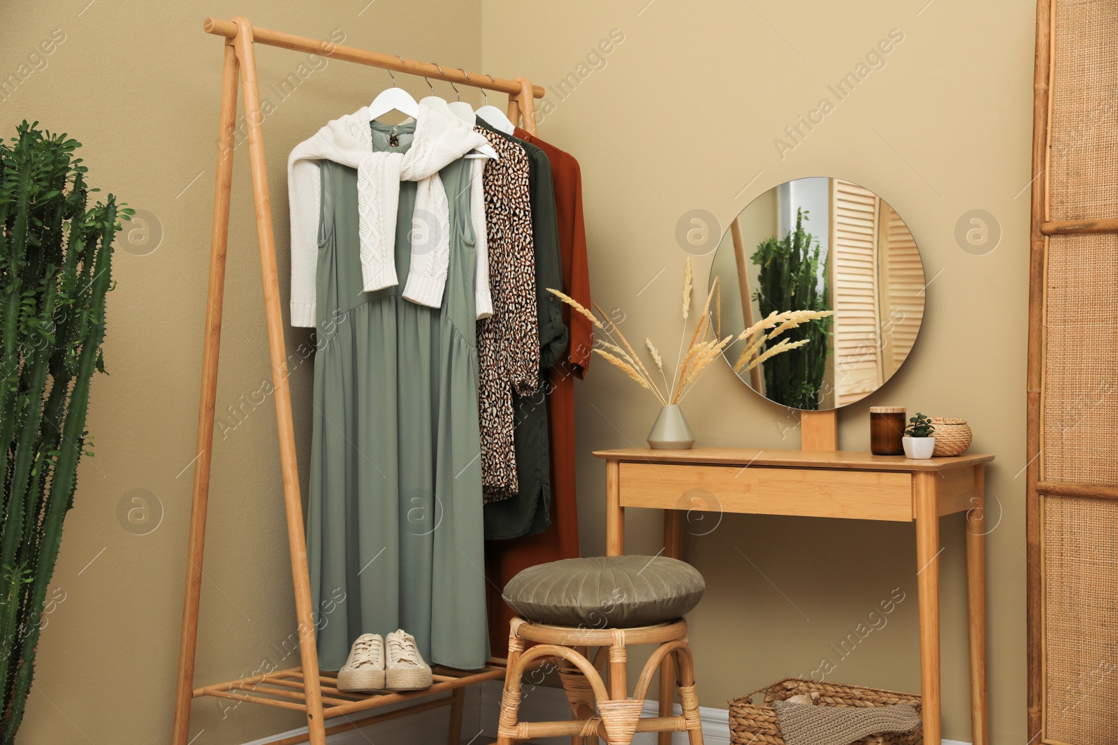 Photo of Modern dressing room interior with clothing rack, wooden table and mirror