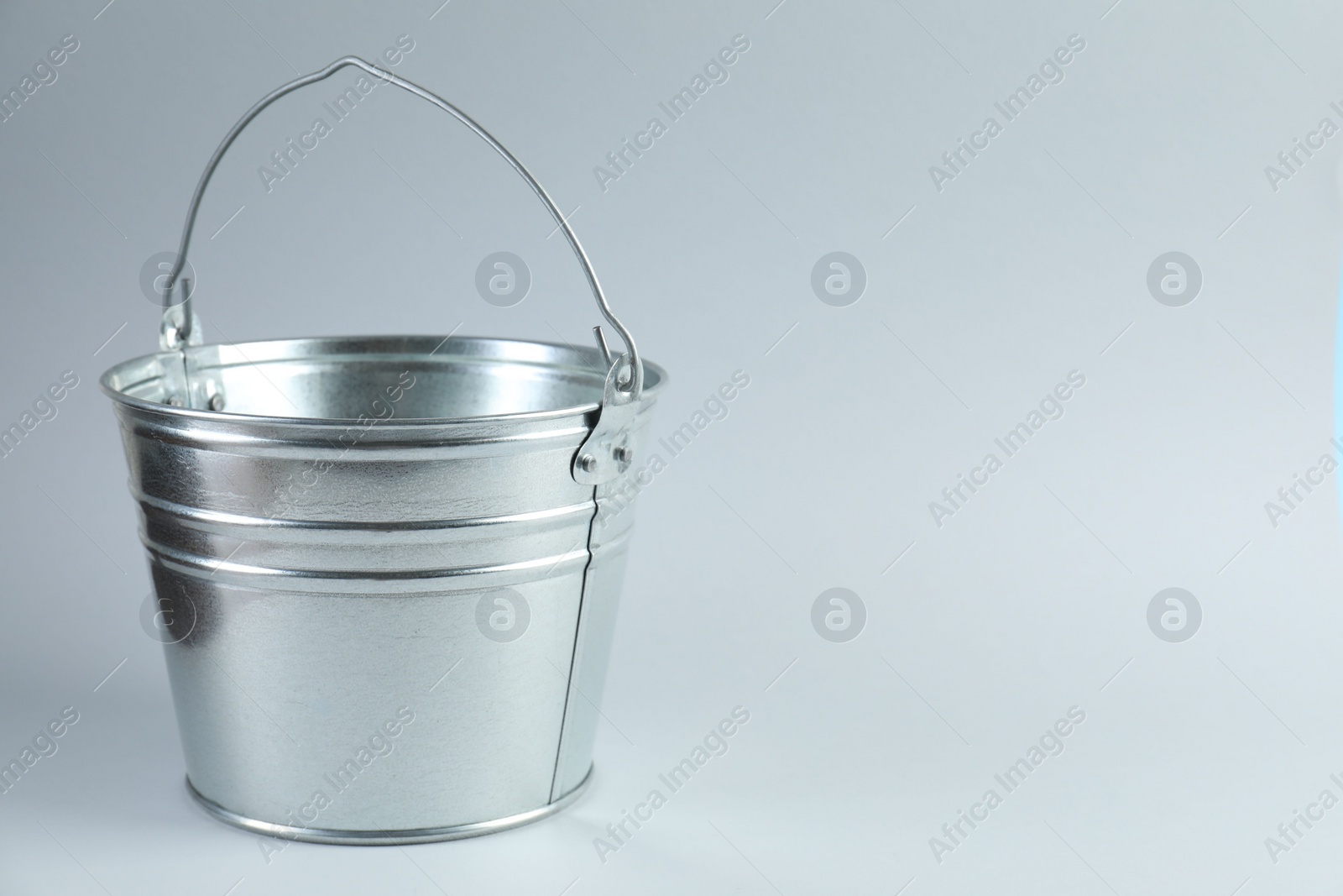 Photo of One shiny metal bucket on white background. Space for text