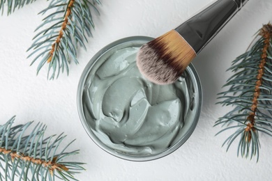 Photo of Professional face mask with spruce and brush on white table, flat lay