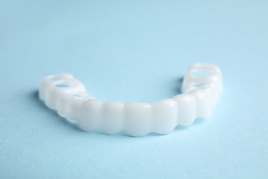 Dental mouth guard on light blue background, closeup. Bite correction
