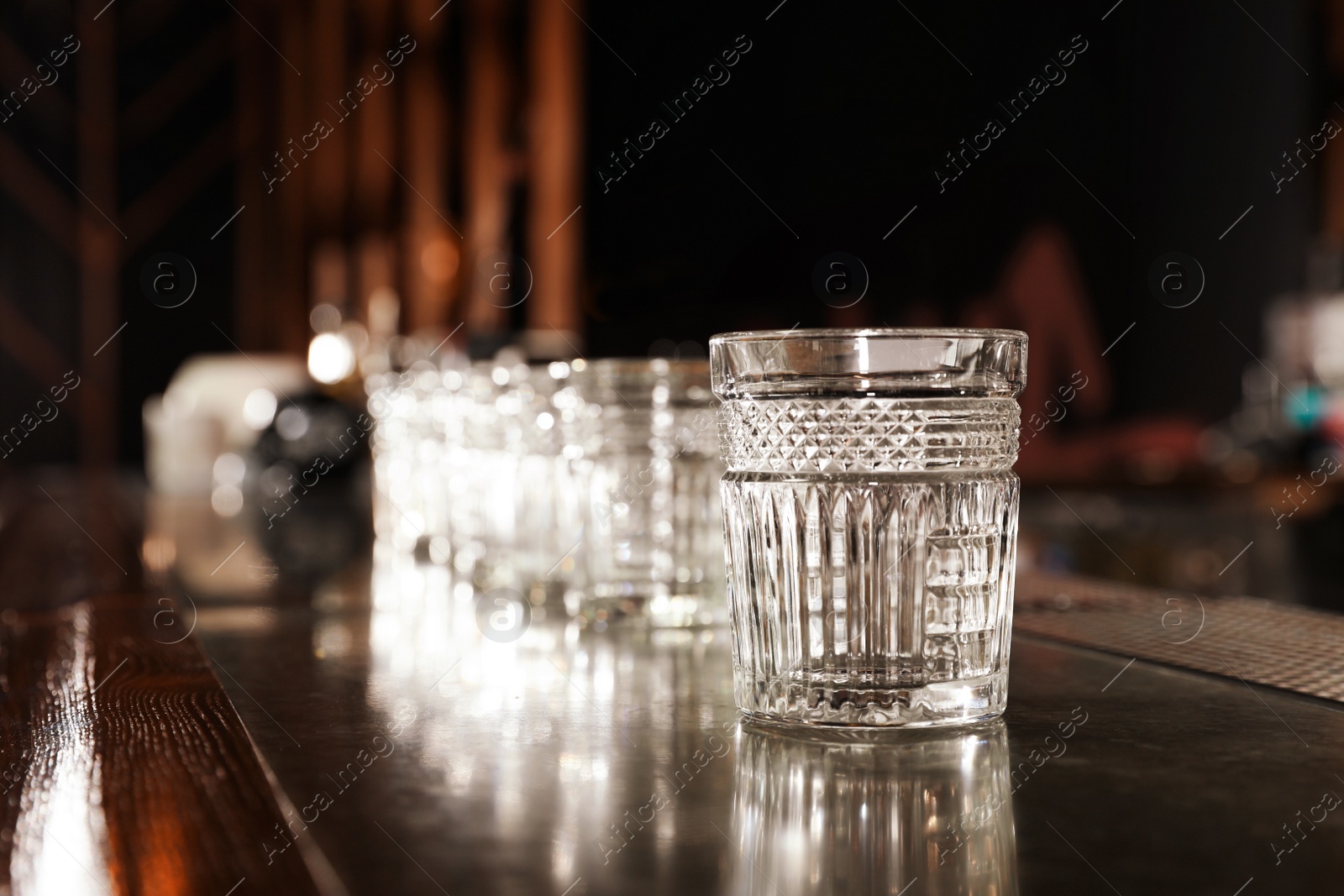 Photo of Empty clean glass on counter in modern bar. Space for text