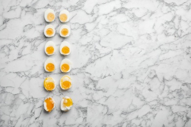 Photo of Various types of boiled eggs on marble background, flat lay with space for text. Cooking time