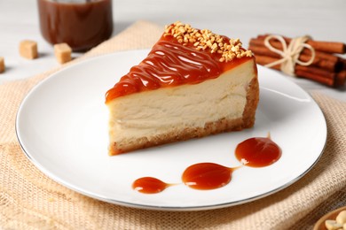 Tasty cheesecake with caramel and nuts served on table