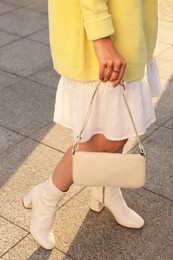 Photo of Fashionable woman with stylish bag on city street, closeup
