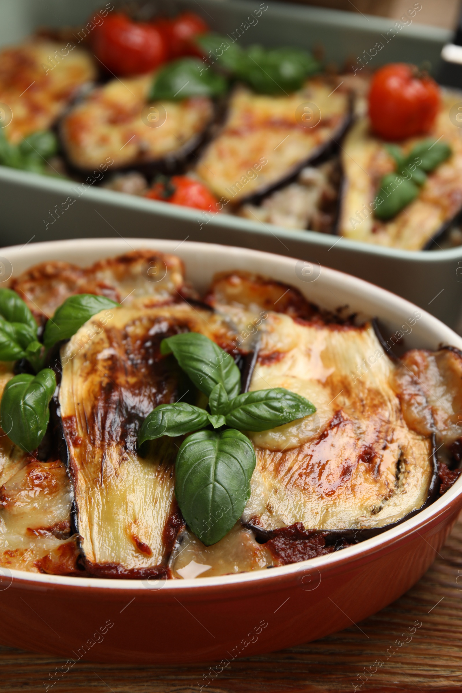 Photo of Delicious eggplant lasagna in baking dish on wooden table