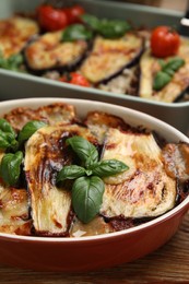 Photo of Delicious eggplant lasagna in baking dish on wooden table