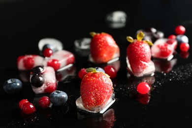 Photo of Different frozen berries on dark table. Keeping fruits fresh