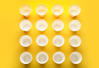 Photo of Paper cups on color background, top view. Picnic table setting