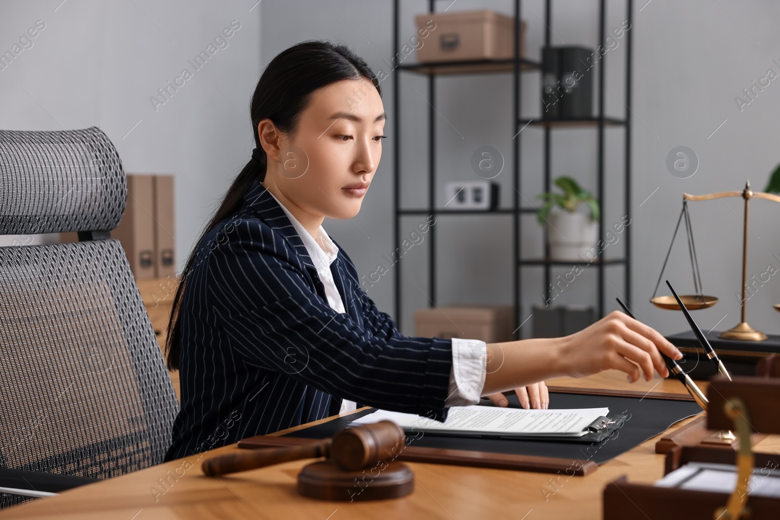 Photo of Notary wearing suit working at table in office