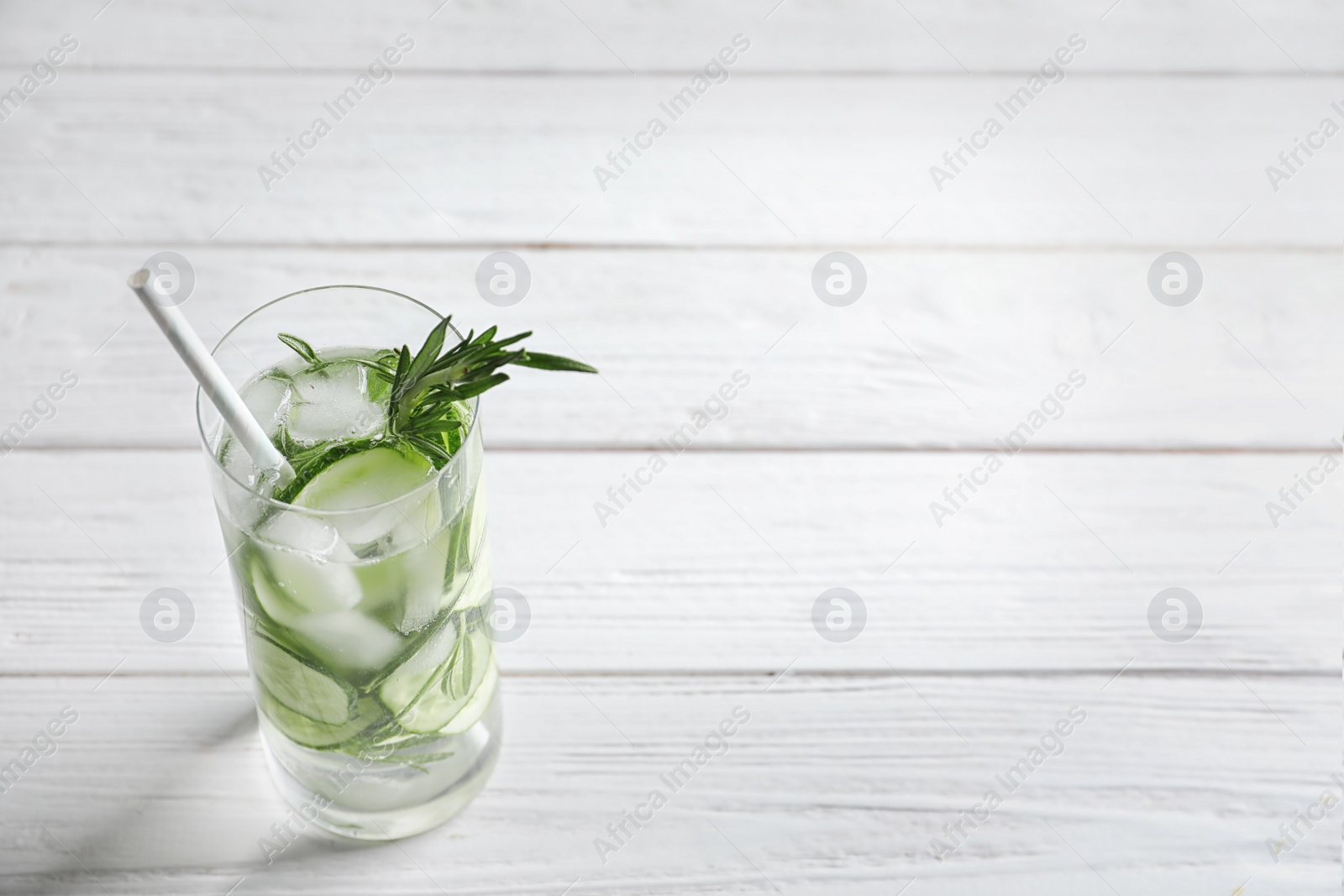 Photo of Natural lemonade with cucumber in glass on wooden table