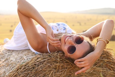 Photo of Beautiful hippie woman on hay bale in field