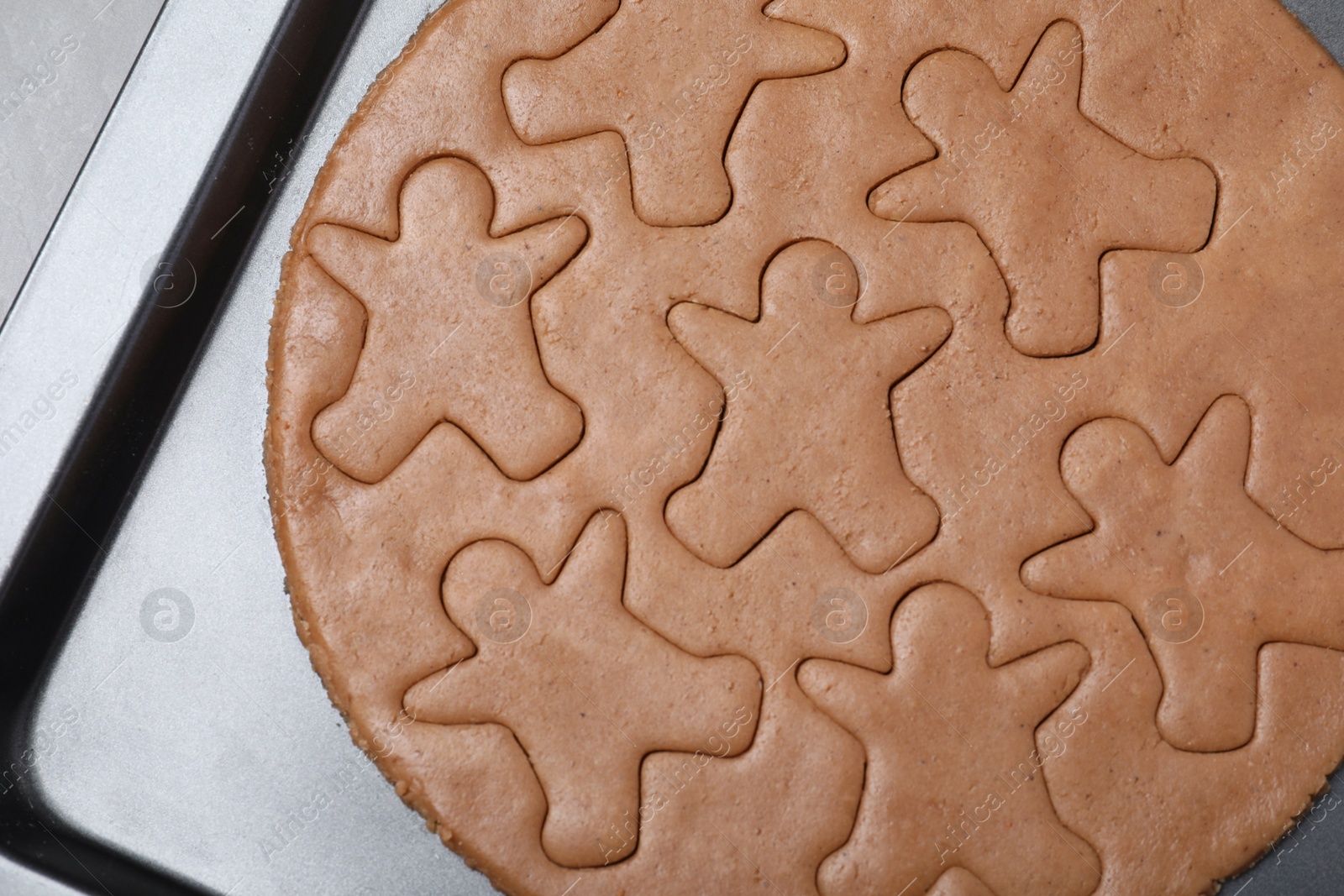 Photo of Making homemade gingerbread man cookies in baking dish, top view