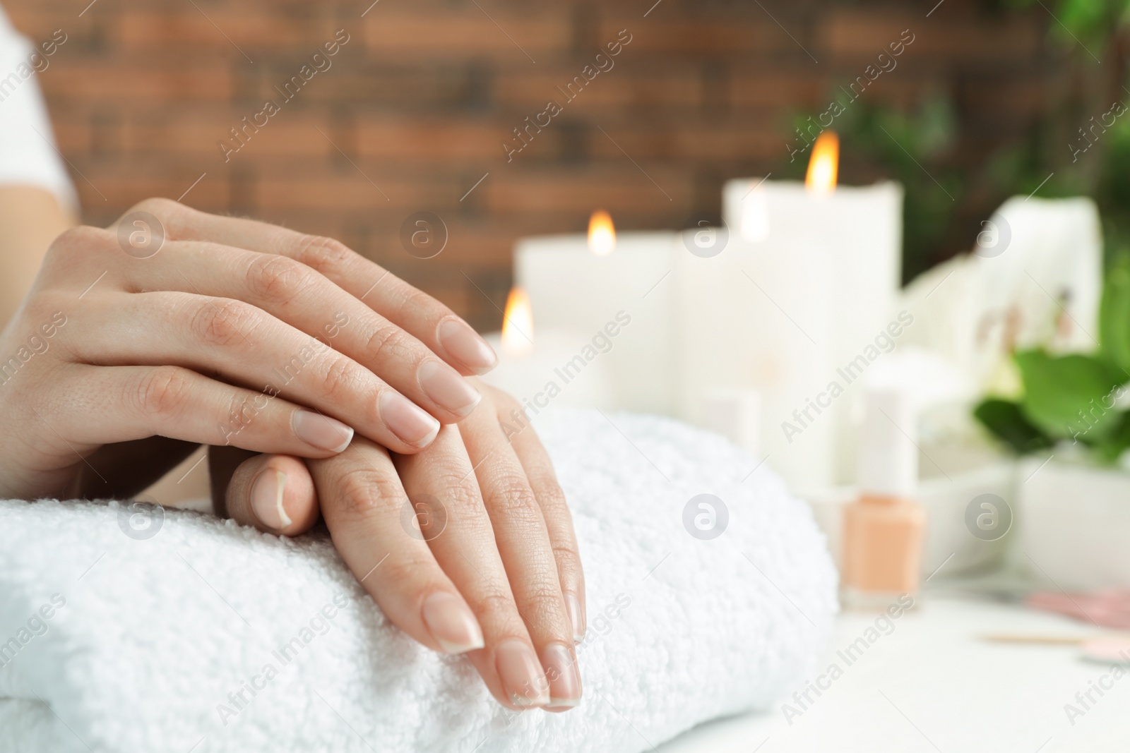 Photo of Woman showing smooth hands on towel at table, closeup with space for text. Spa treatment