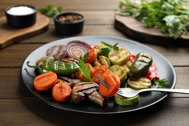 Photo of Delicious grilled vegetables with parsley on wooden table, closeup