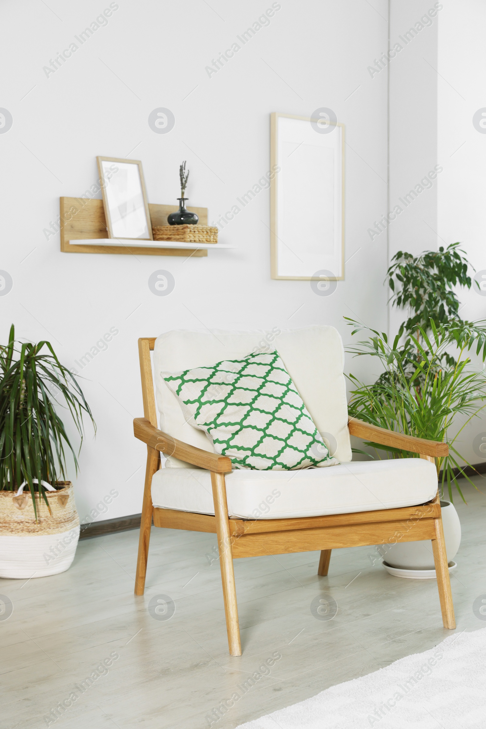 Photo of Stylish room interior with comfortable armchair and beautiful houseplants