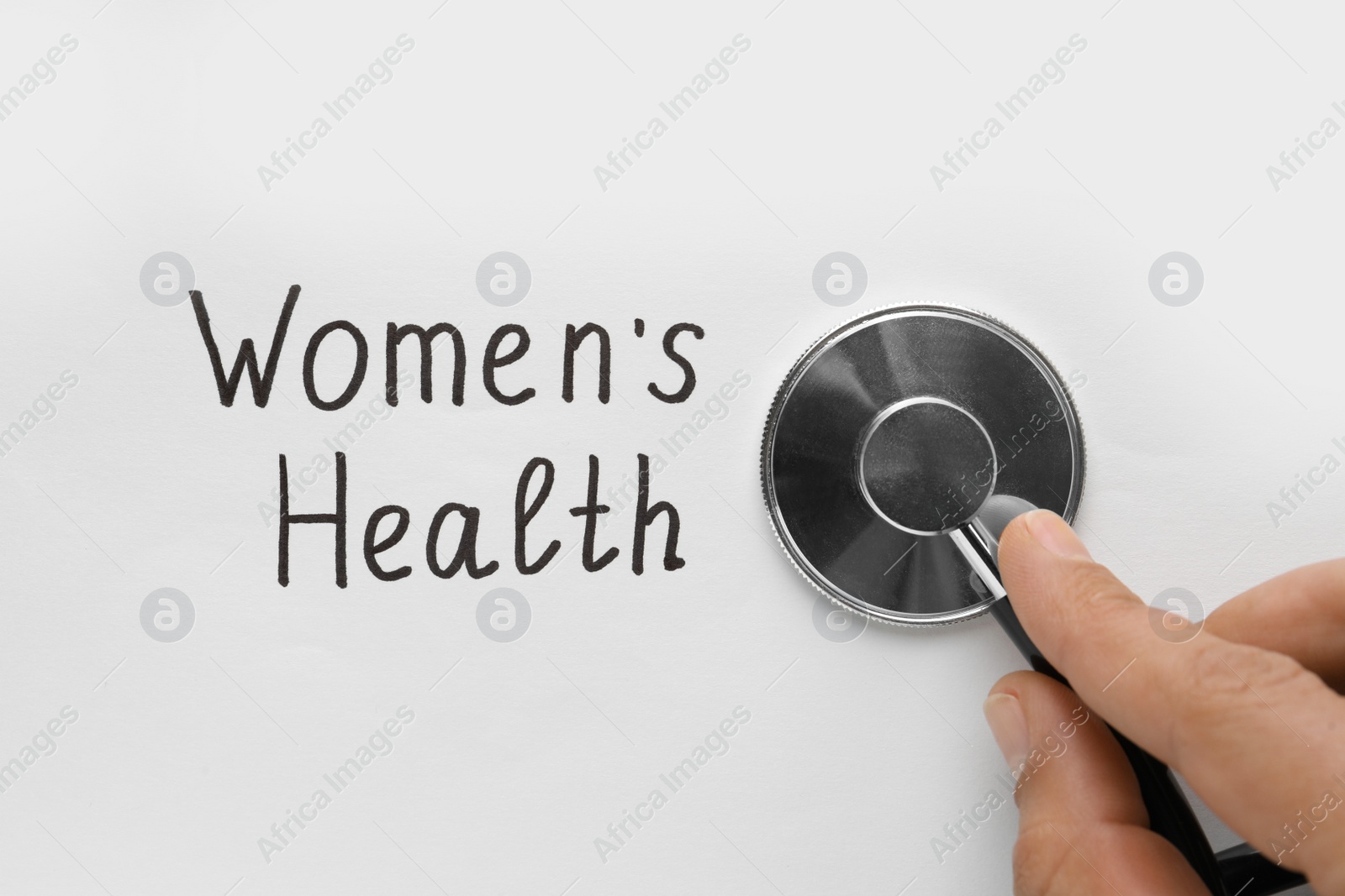 Photo of Doctor with stethoscope and words Women's Health on white background, top view