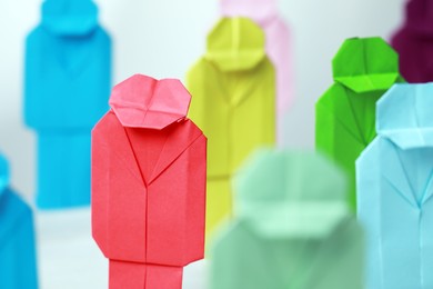 Photo of Many colorful paper figures on table, closeup. Recruiter searching employee