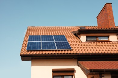 Photo of House with installed solar panels on roof. Alternative energy