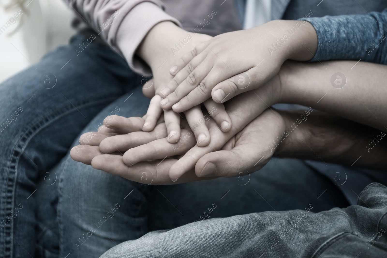 Image of Closeup view of happy family holding hands. Black and white effect