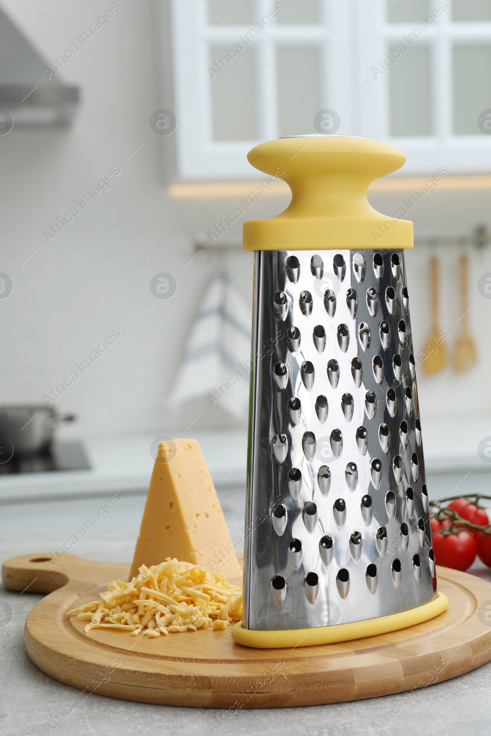 Photo of Grater and cheese on table in kitchen