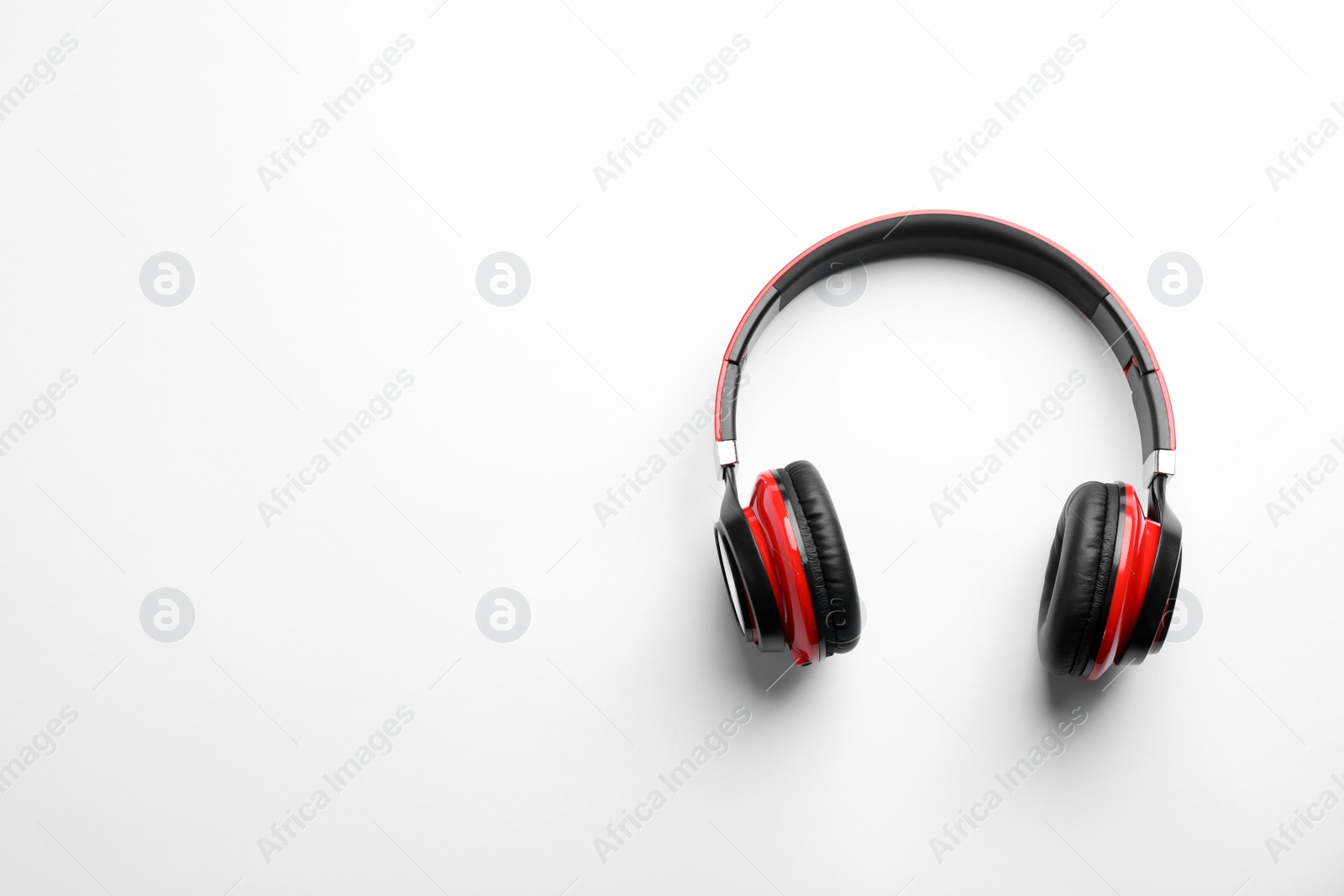 Photo of Stylish modern headphones with earmuffs on white background, top view. Space for text