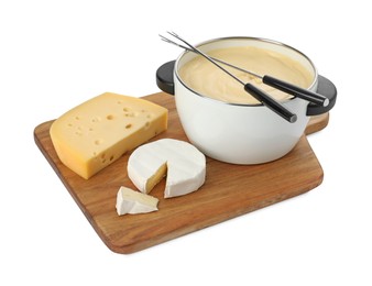 Photo of Fondue with tasty melted cheese, forks and pieces isolated on white