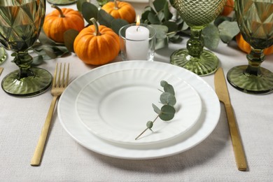 Photo of Beautiful autumn table setting. Plates, cutlery, glasses, pumpkins and floral decor