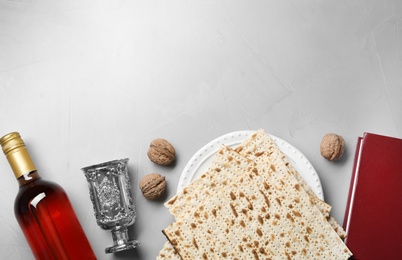 Photo of Flat lay composition with symbolic Passover (Pesach) items on light background, space for text