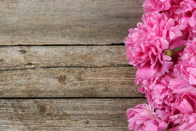 Photo of Beautiful pink peonies on wooden table, flat lay. Space for text