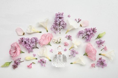 Photo of Luxury perfume and floral decor on white background, flat lay