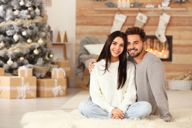 Image of Happy couple in living room decorated for Christmas