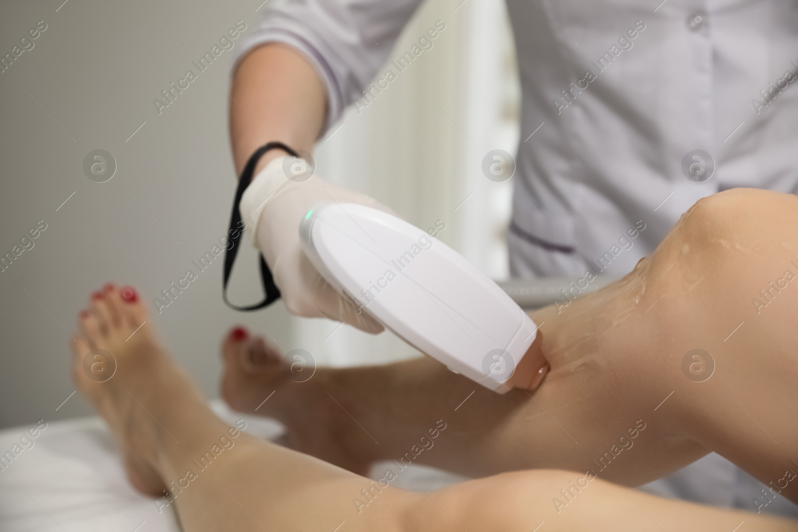 Photo of Woman undergoing laser epilation procedure in beauty salon, closeup