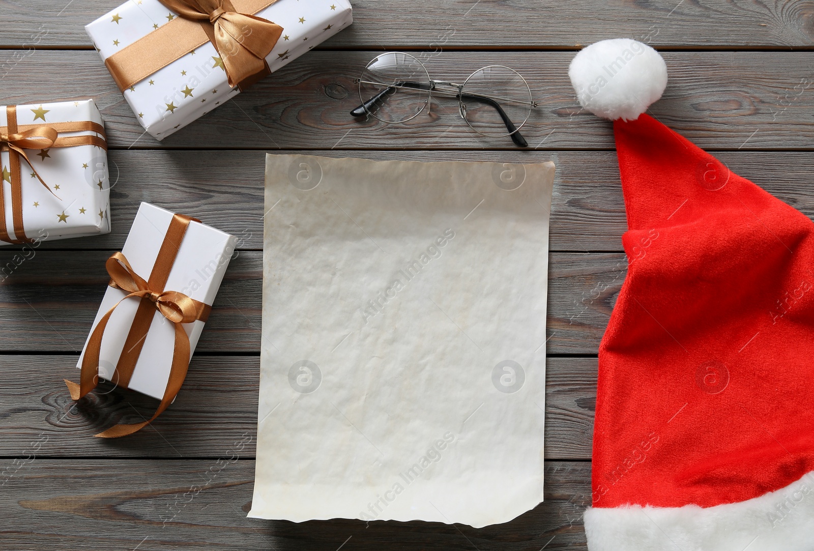 Photo of Flat lay composition with blank paper sheet and Christmas decor on wooden table, space for text. Letter for Santa