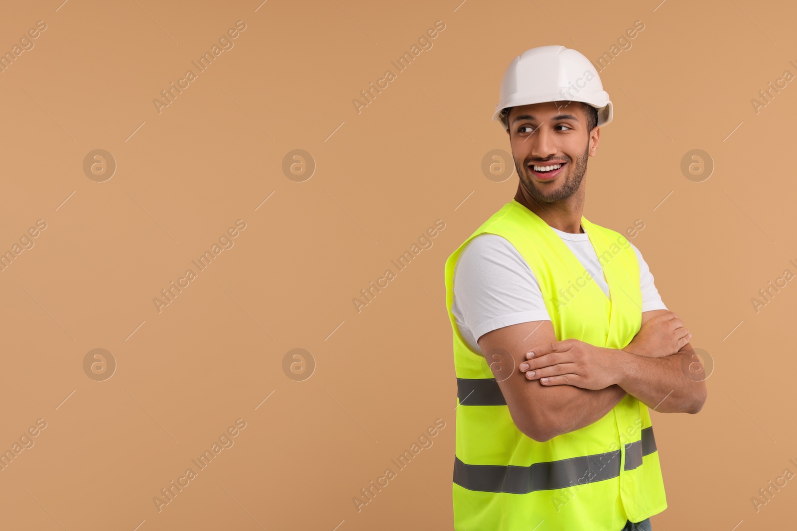 Photo of Engineer in hard hat on beige background, space for text