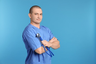 Portrait of medical assistant with stethoscope on color background. Space for text