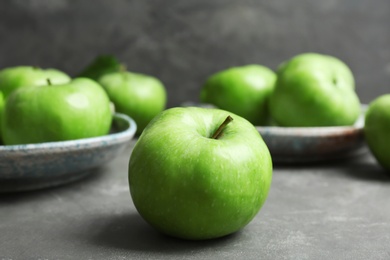 Fresh green apples on grey table