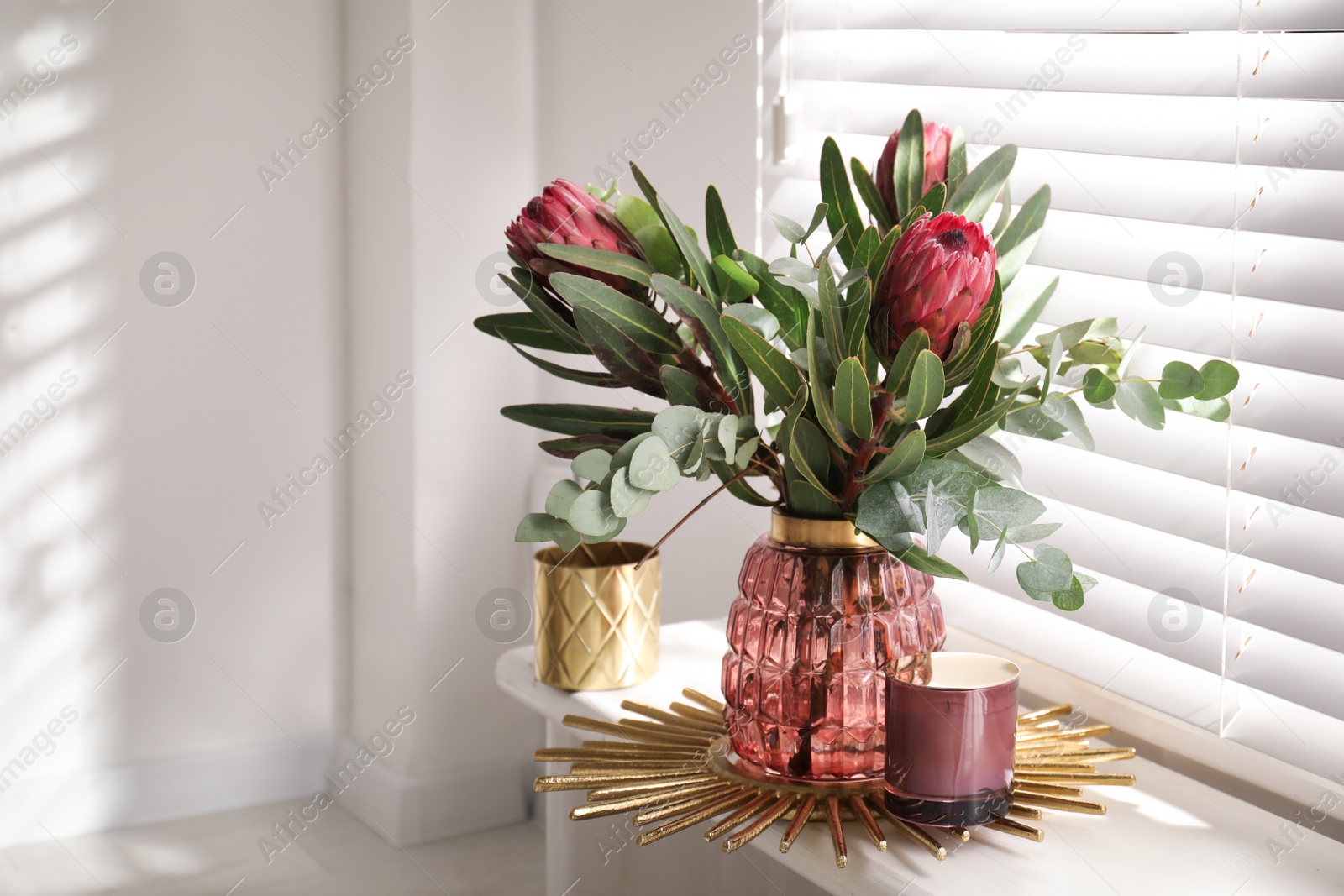 Photo of Vase with bouquet of beautiful Protea flowers on window sill indoors