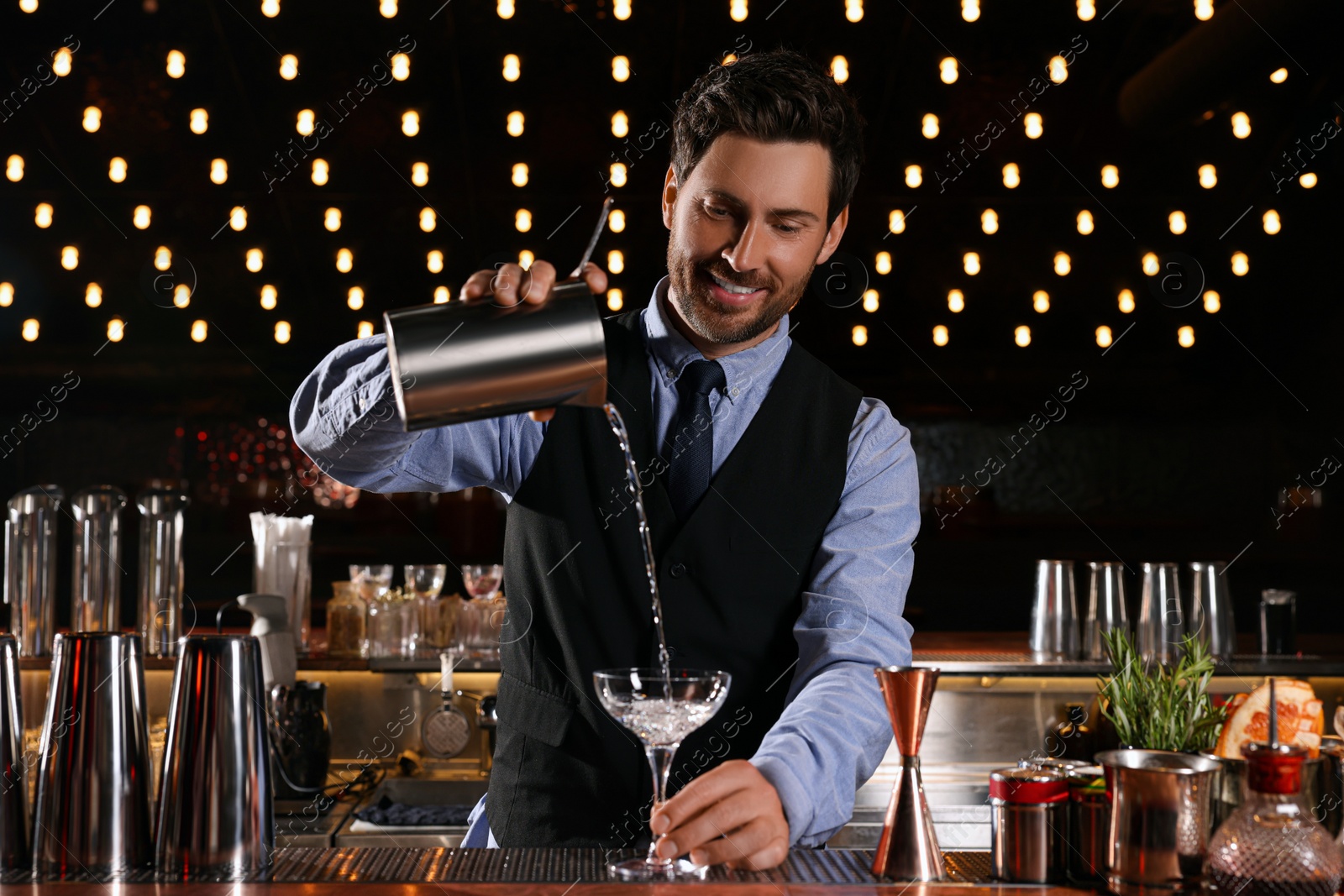 Photo of Bartender preparing fresh alcoholic cocktail in bar