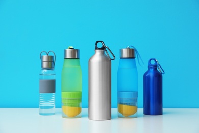 Photo of Different water bottles for sports on color background