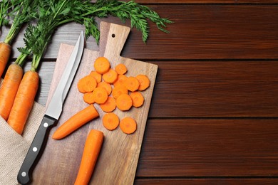 Photo of Tasty fresh carrot on wooden table, flat lay. Space for text