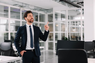 Photo of Happy real estate agent pointing in office