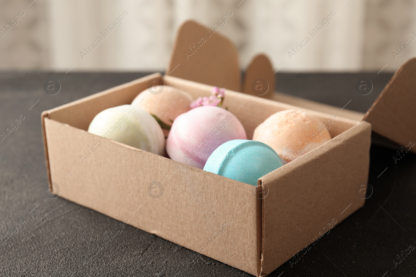 Photo of Carton box with bath bombs on black table