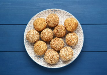 Delicious sesame balls on blue wooden table, top view