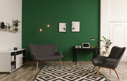 Photo of Modern living room interior with workplace near green wall