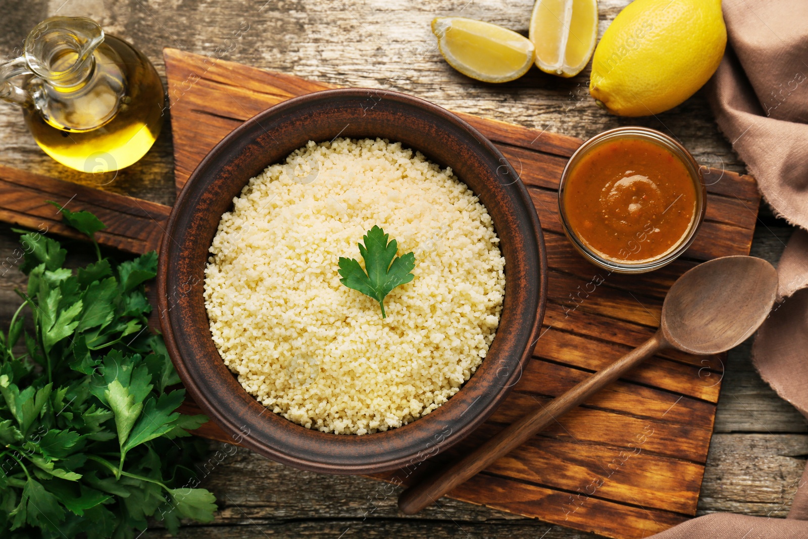 Photo of Tasty couscous and ingredients on wooden table, flat lay