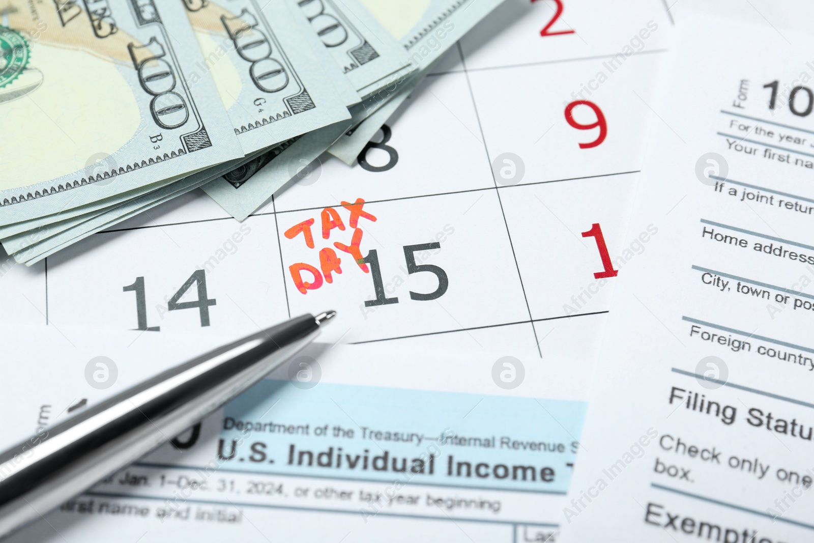 Photo of Tax day. Calendar with date reminder, documents, dollar banknotes and pen on table