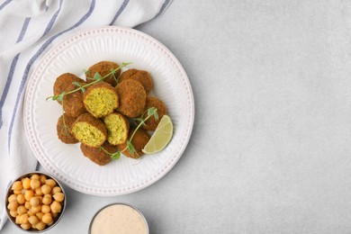 Photo of Delicious falafel balls served on light table, flat lay. Space for text