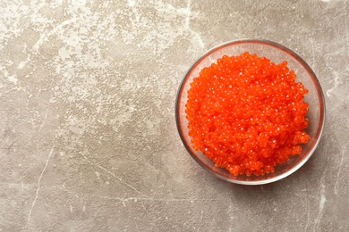 Photo of Bowl with delicious red caviar on table