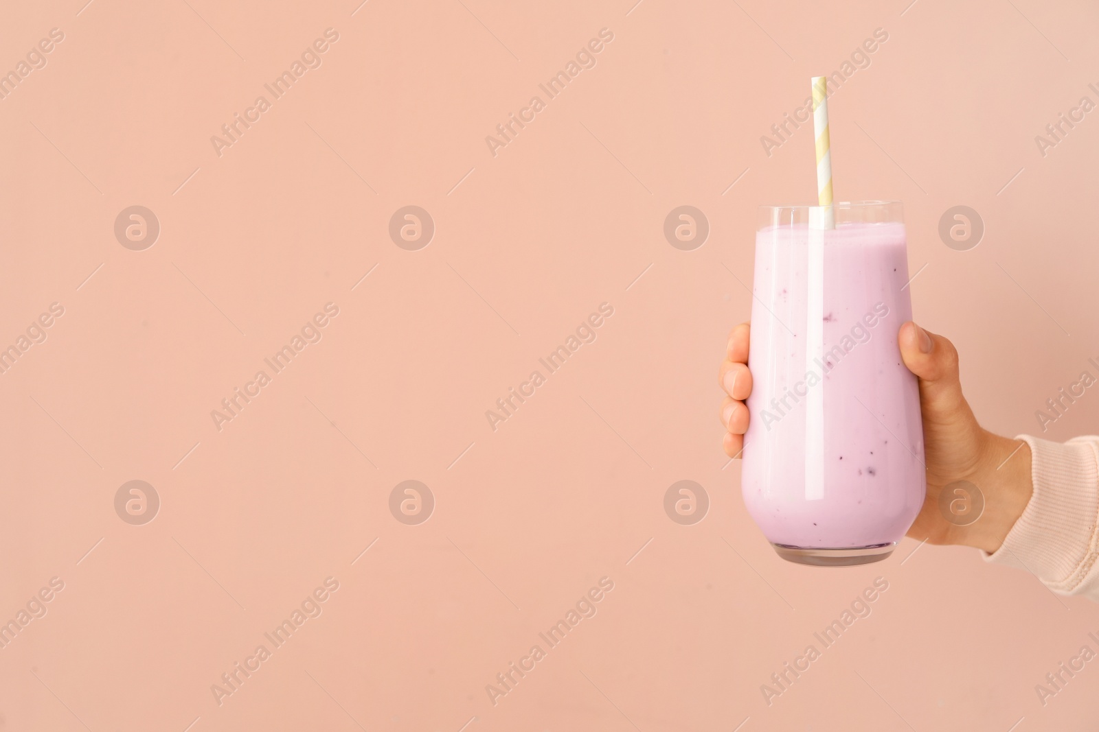 Photo of Woman holding fig smoothie on pink background, closeup. Space for text