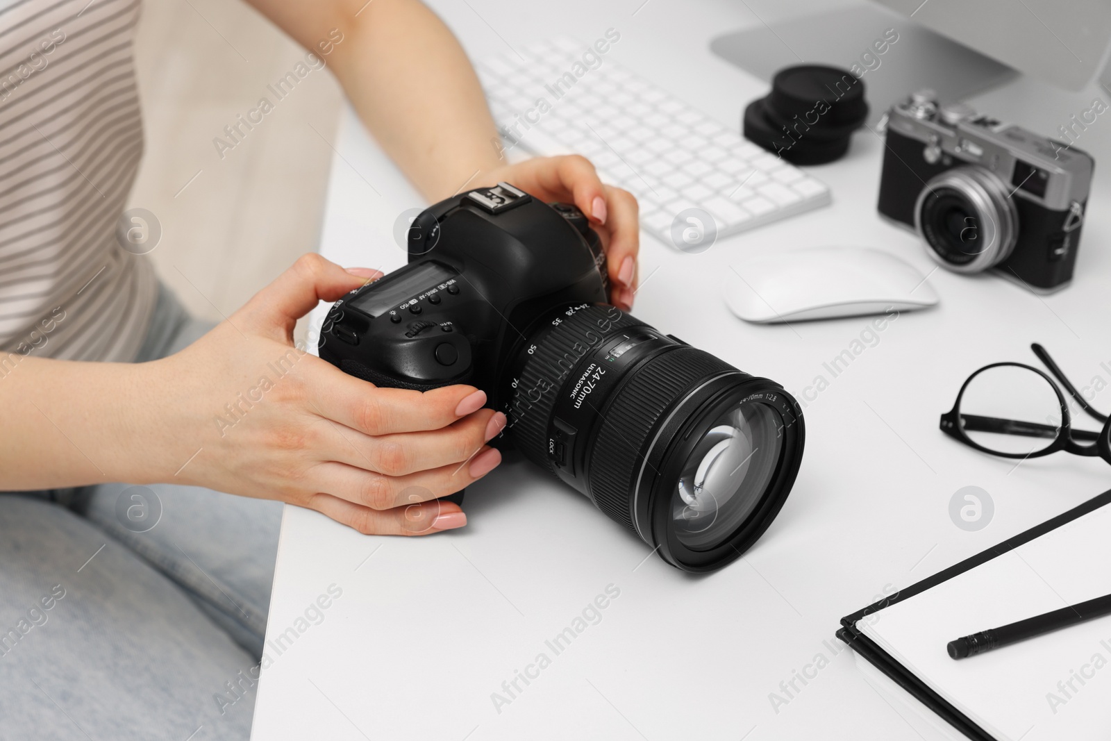 Photo of Photographer with camera at white table indoors, closeup